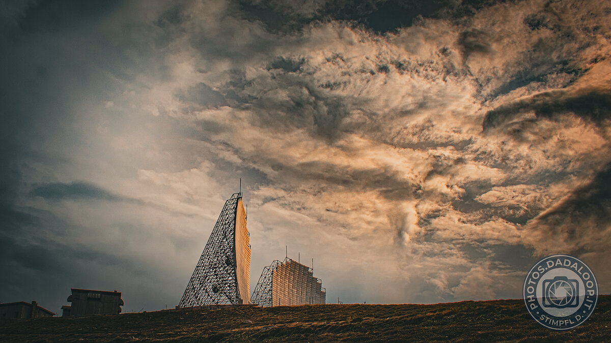 Antenne paraboliche illuminate dal sole sotto un cielo nuvoloso