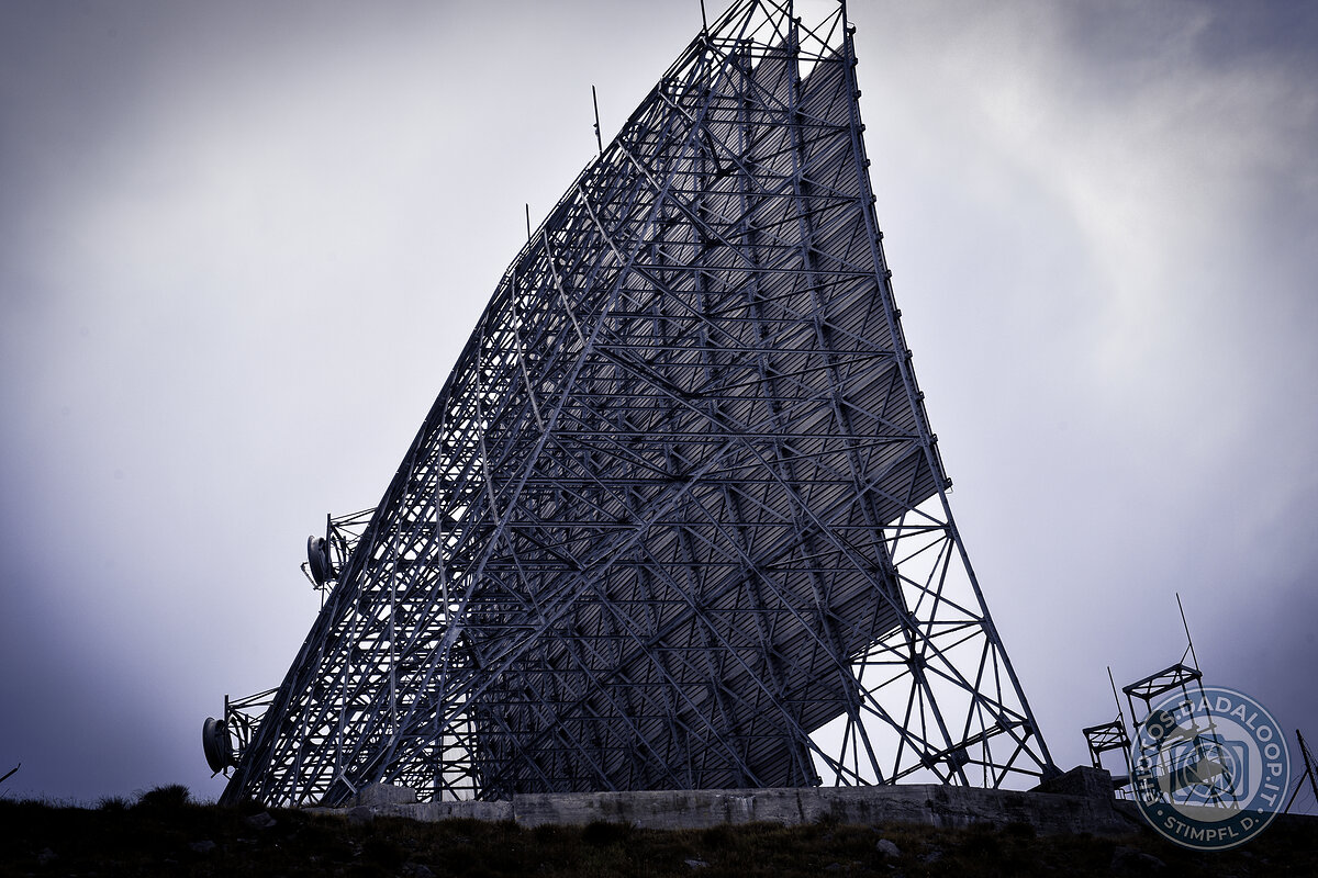 Imponente antenna parabolica verso il cielo plumbeo