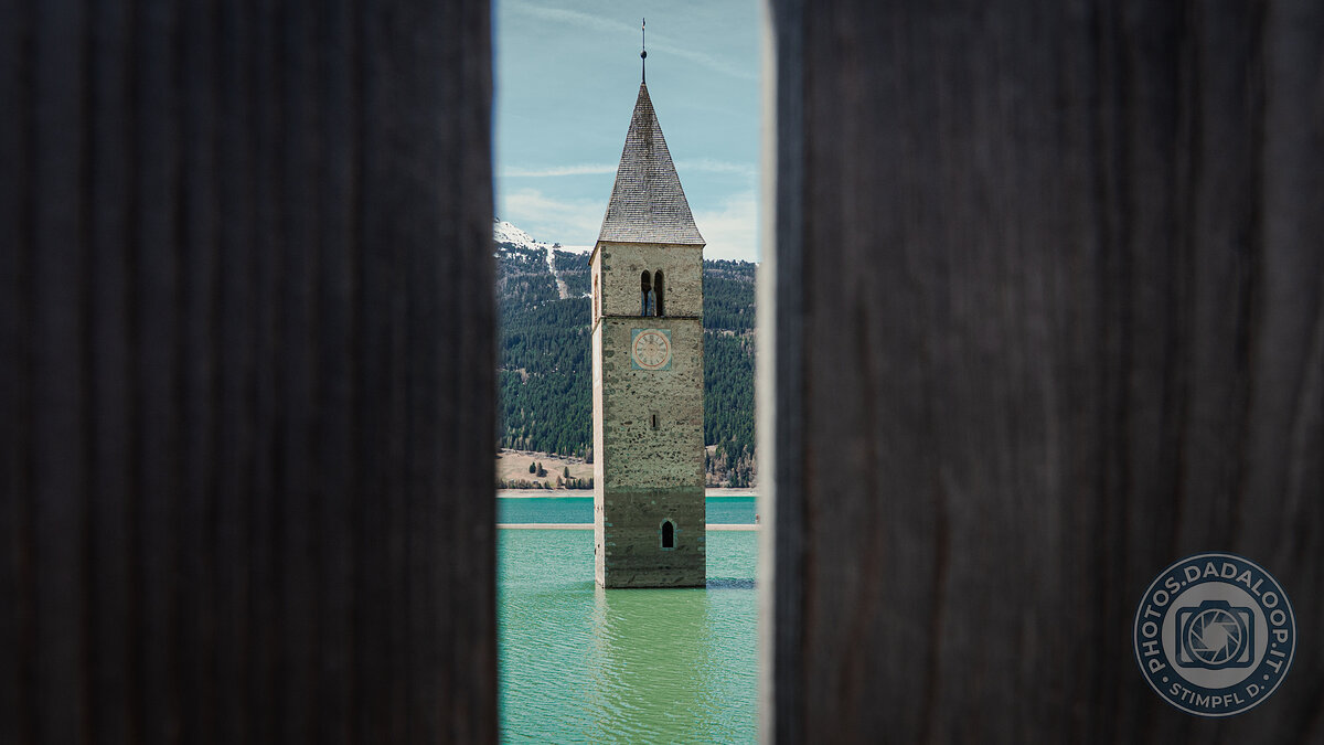 Il campanile sommerso di Curon Venosta incorniciato tra assi di legno