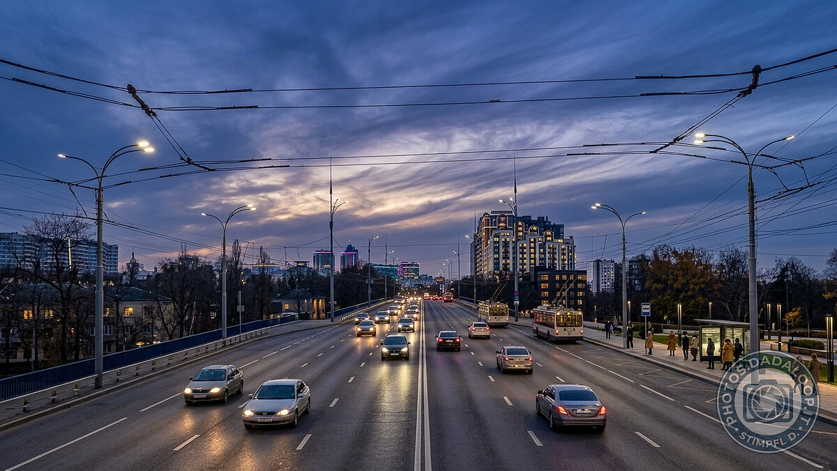 Evening traffic on illuminated bridge, cloudy sky