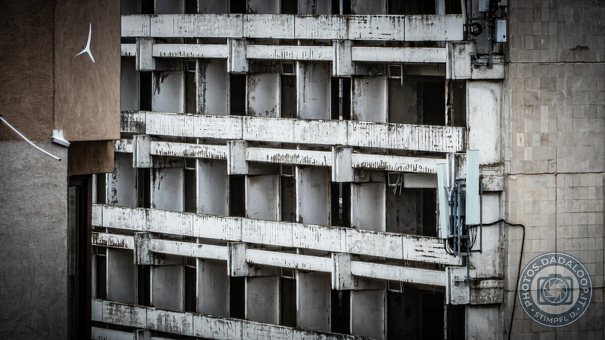 Facade of an abandoned building with antennas, decaying atmosphere