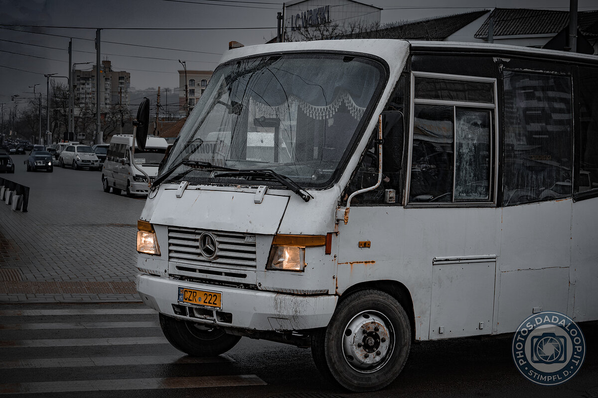 White bus stopped on a pedestrian crossing on a gray day