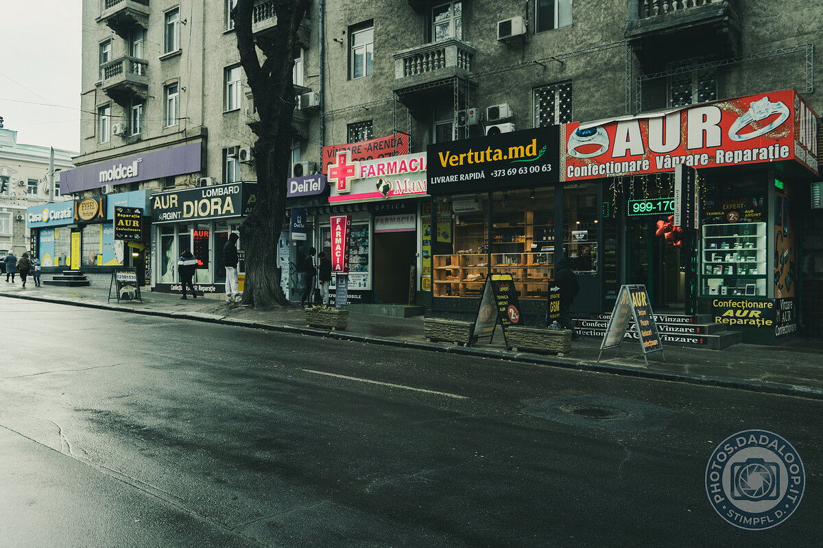 Illuminated shop windows on a gray and wet urban street