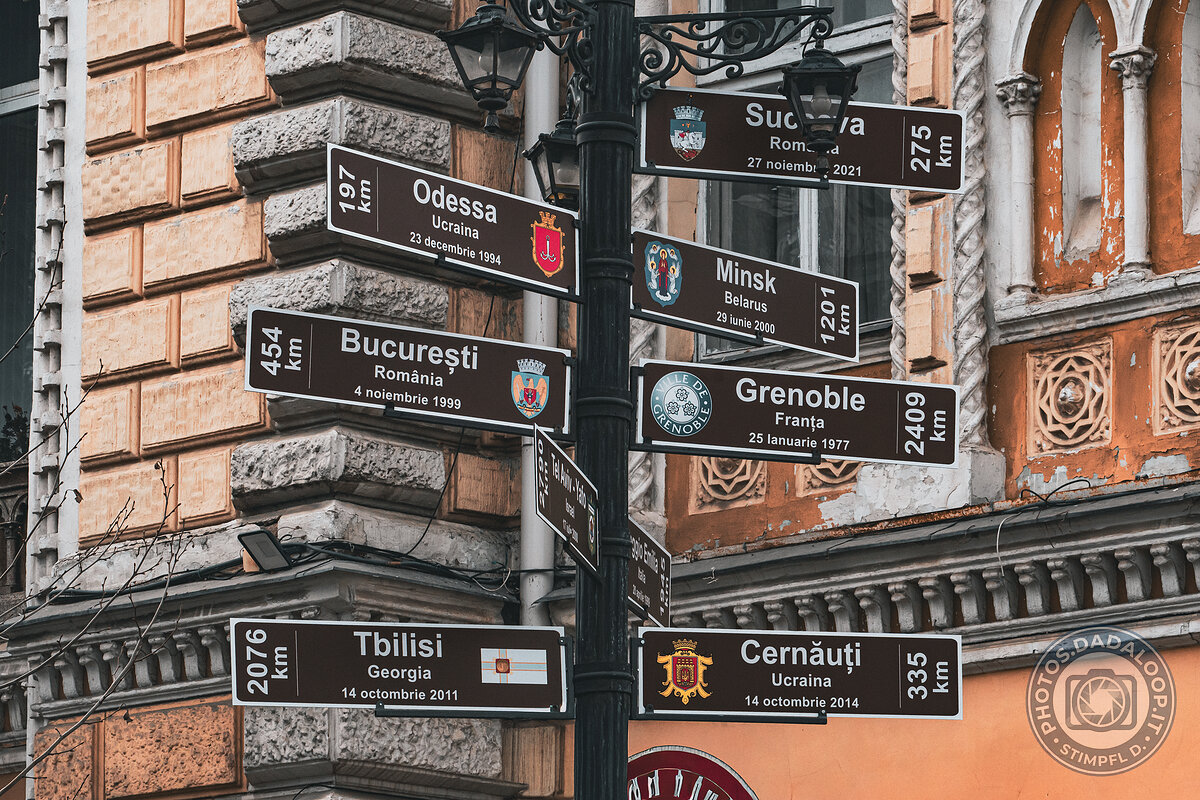 Multiple road signs on a pole in Chișinău