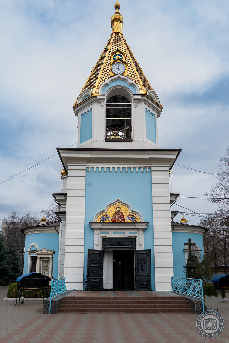 Blue Orthodox church with golden dome and clock