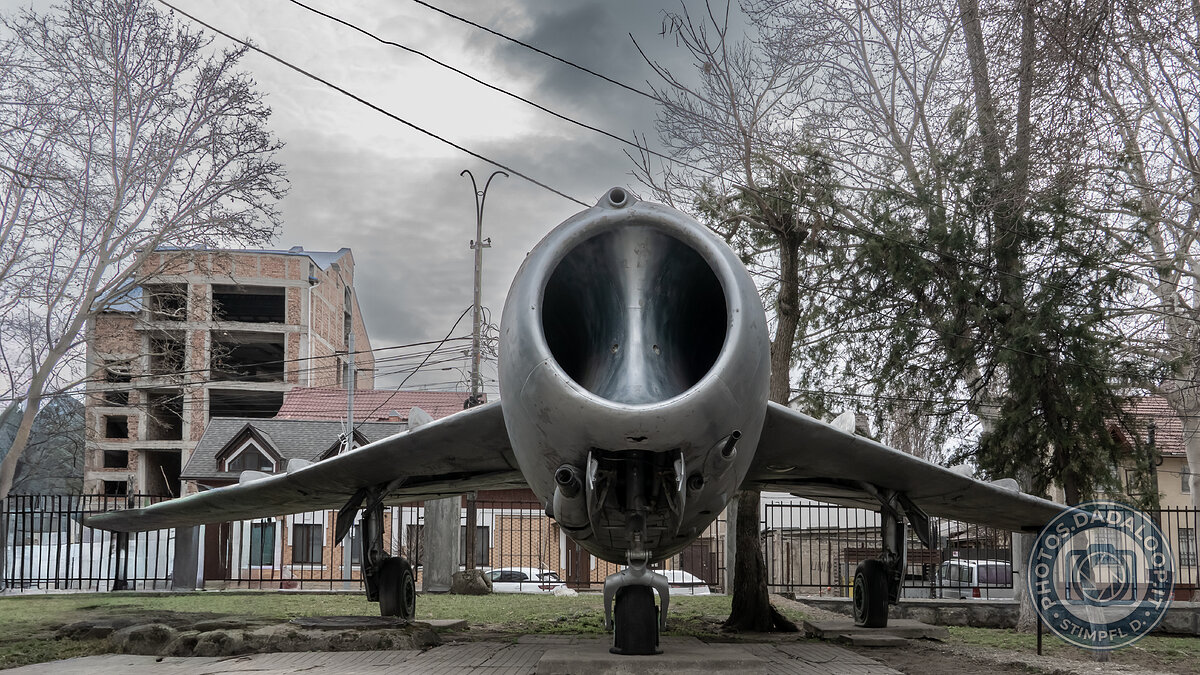 Nose of an abandoned warplane, under a leaden sky