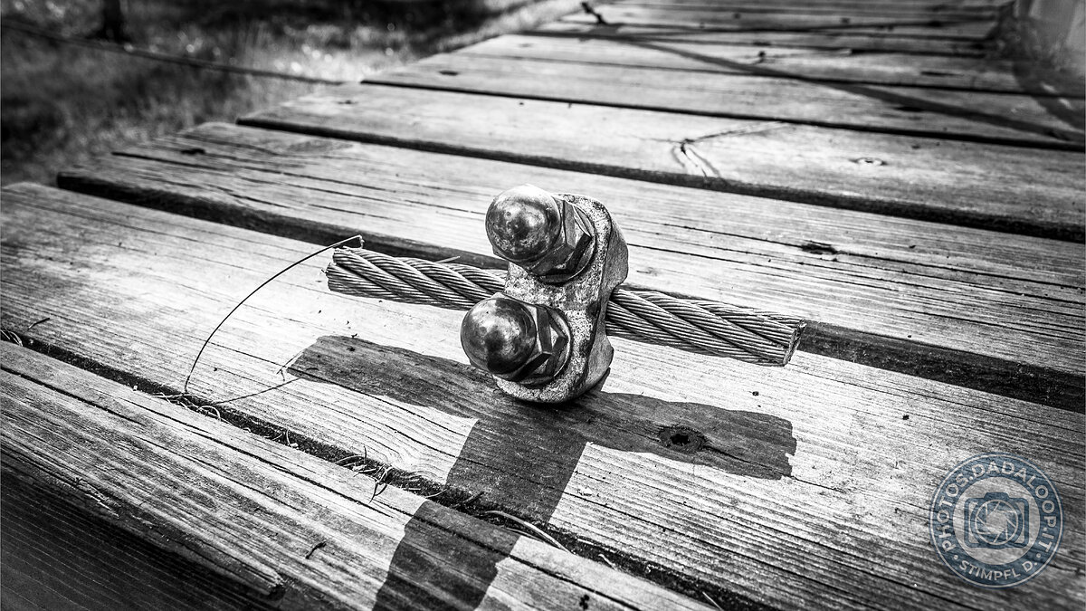 Dettaglio di cavo e morsetto su passerella di legno