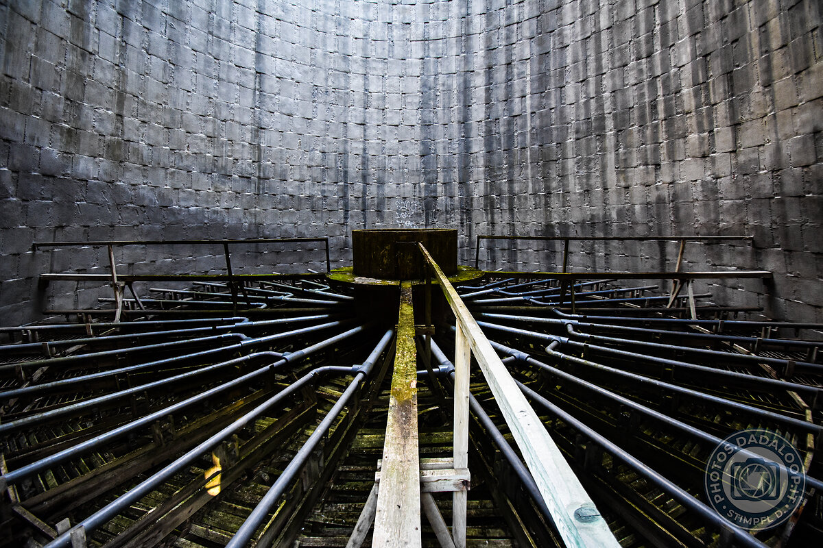 Interno di una struttura industriale abbandonata con tubi convergenti