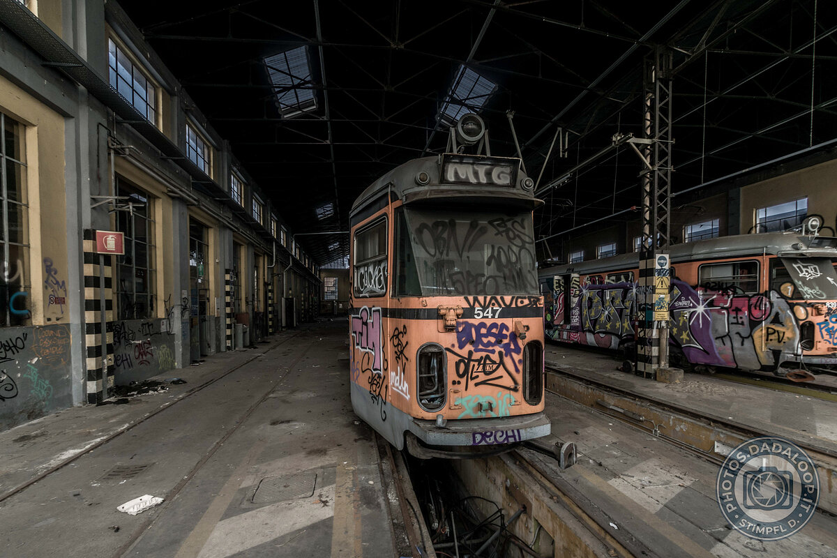 Tram abbandonati e graffiti in un deposito industriale dismesso