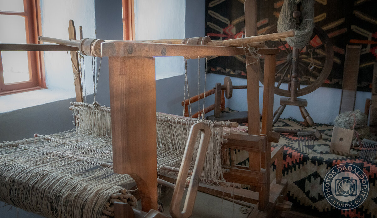 Antico telaio in legno con fili tesi in una stanza illuminata