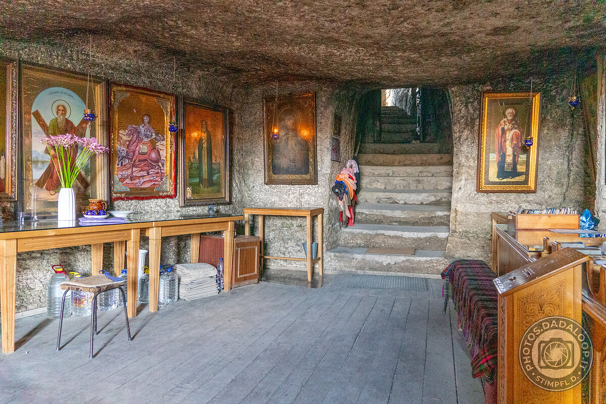 Interno di chiesa rupestre con icone e scale in pietra