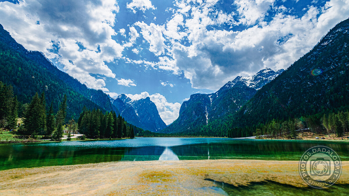 Mountain lake among the Alps with cloudy sky