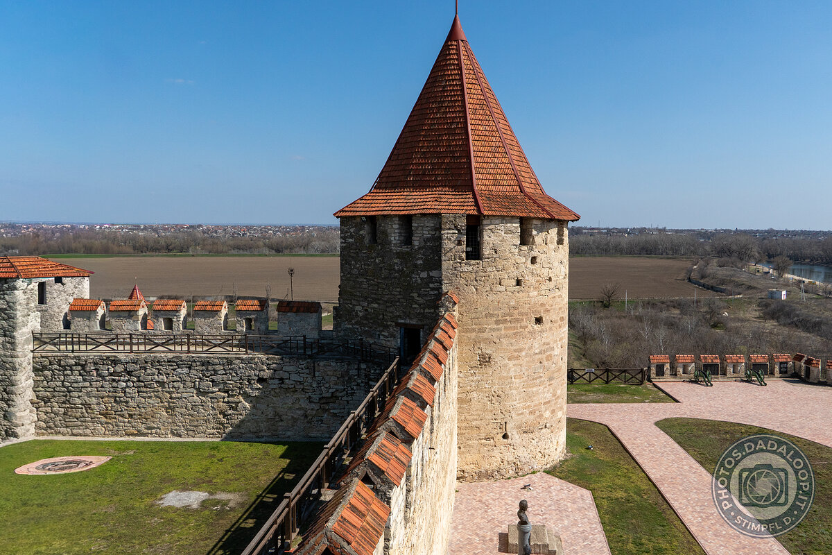 Fortezza medievale: torre di guardia e mura merlate sotto il cielo azzurro