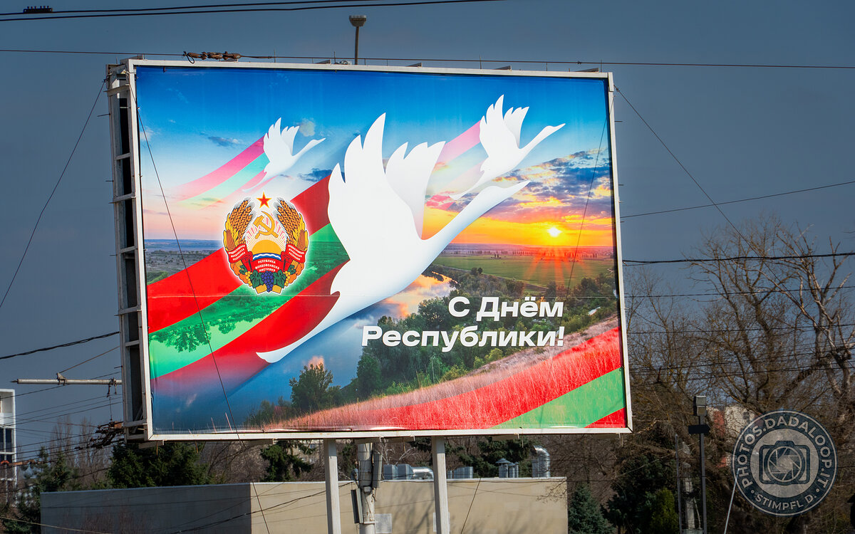 Manifesto celebrativo in Transnistria: bandiera, colombe e tramonto