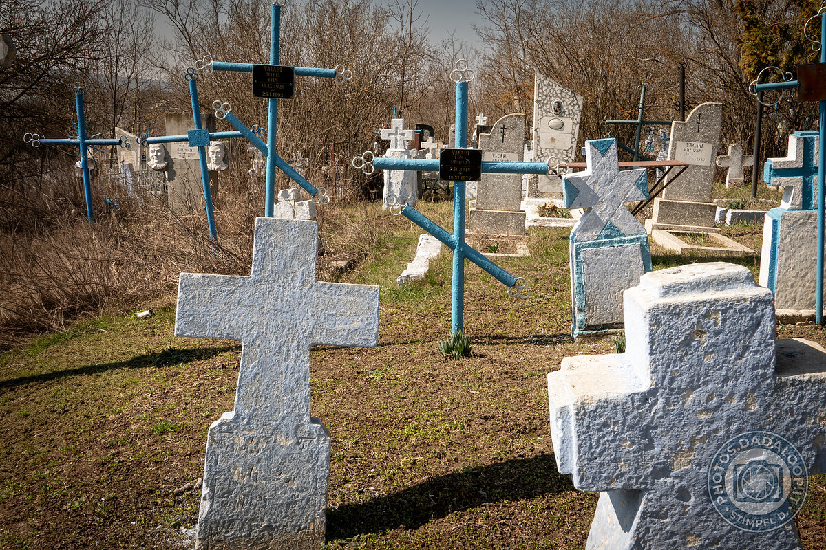 Croci azzurre e lapidi in un cimitero di campagna