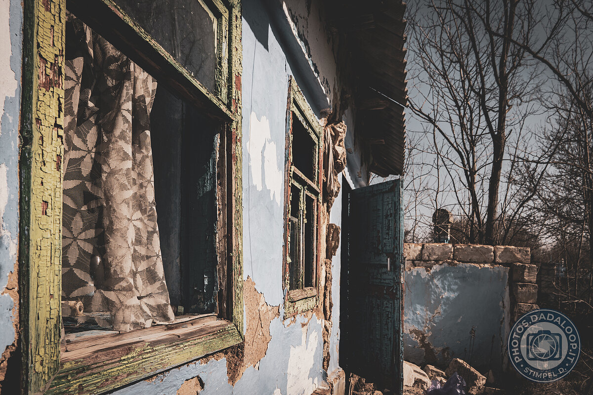 Finestre e porta di una casa abbandonata, intrisa di decadenza